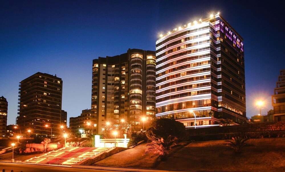 Edificio alto con balcones y fachada iluminada de noche