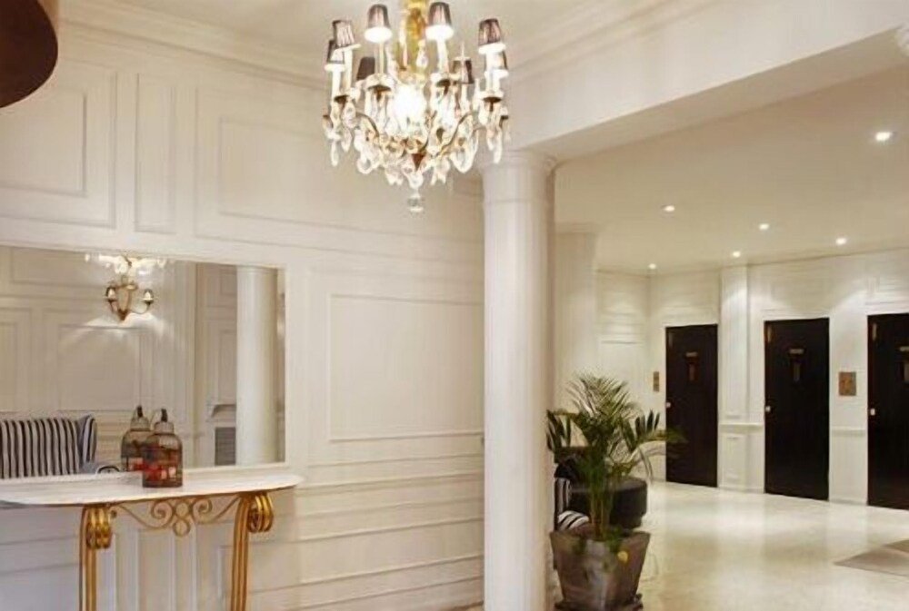 Hall amplio con una gran araña, recepción y una planta