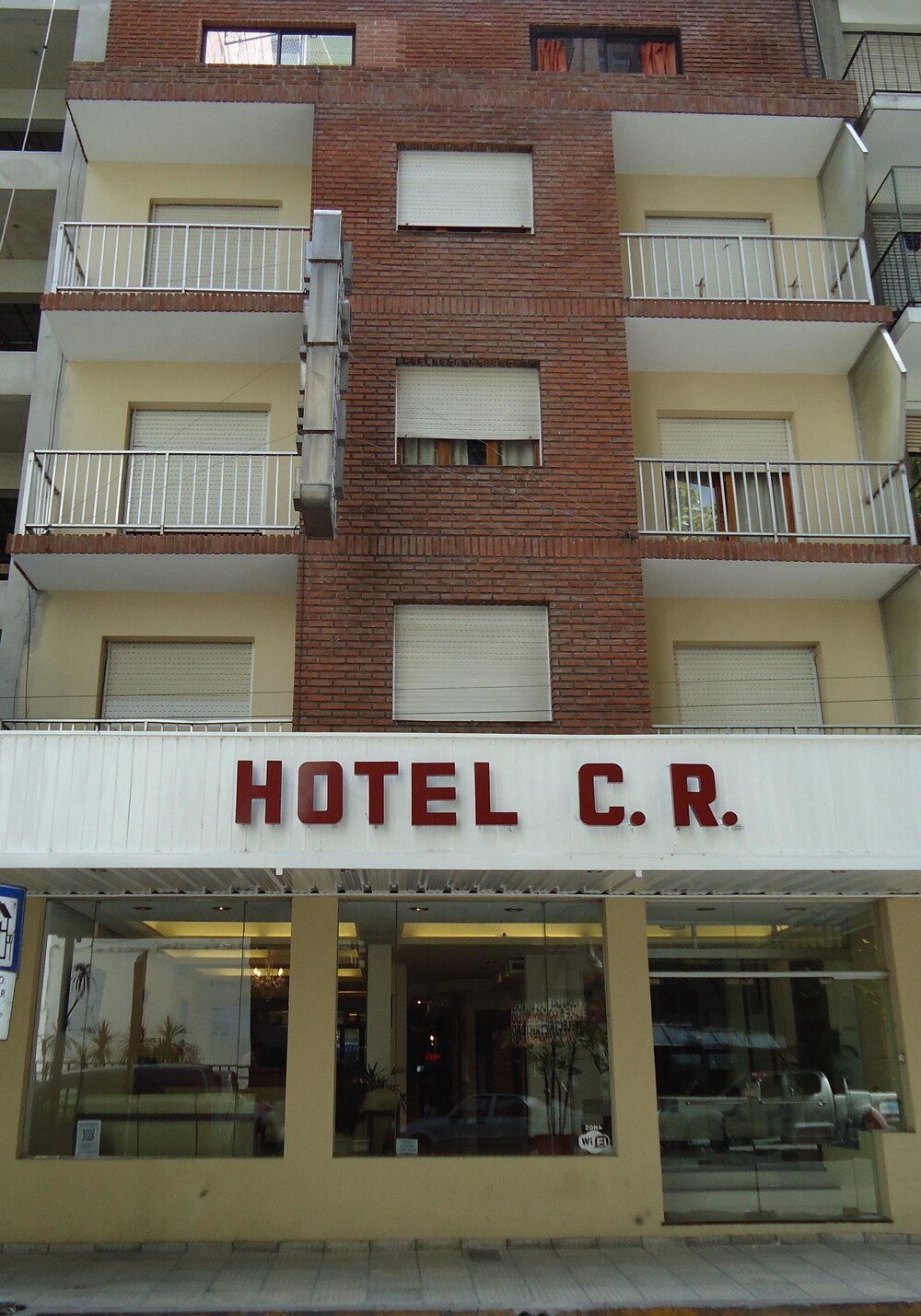 Frente del edificio con cartel de hotel y balcones